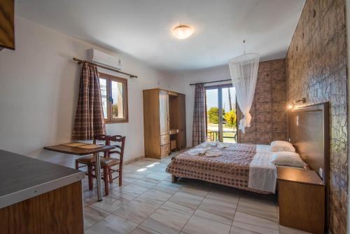 a bedroom with a bed and a table and a kitchen at Mirage Arillas Studio Type B11 in Arillas