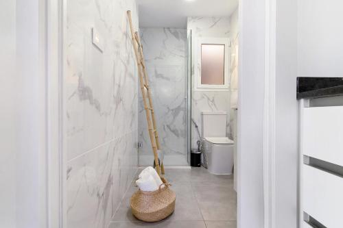 La salle de bains est pourvue d'un mur en marbre blanc. dans l'établissement Casa Luna Kingbed and Jacuzzi, à Maspalomas