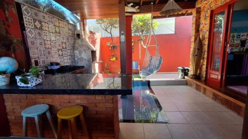a kitchen with two stools at a counter in a restaurant at Casa chalé in Itajaí