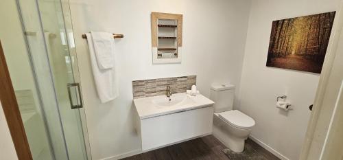 une salle de bain blanche avec un lavabo et des toilettes dans l'établissement Isobel's Rose Cottage, à Hanmer Springs