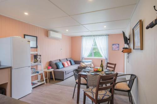 a kitchen and living room with a table and a couch at Isobel's Rose Cottage in Hanmer Springs
