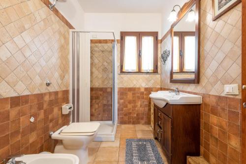 a bathroom with a toilet and a shower and a sink at Masone Murgioni in Castiadas
