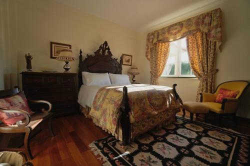 SetubalにあるRocha's House - Setúbalのベッドと椅子と窓のある寝室