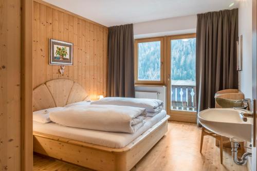 a bedroom with a bed and a sink and a tub at Adlerhorst Rotkehlchen in Santa Valburga St. Walburg