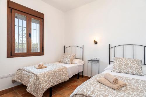 エル・パルマルにあるEl Mirador de Castilnovoのベッド2台と窓のある寝室