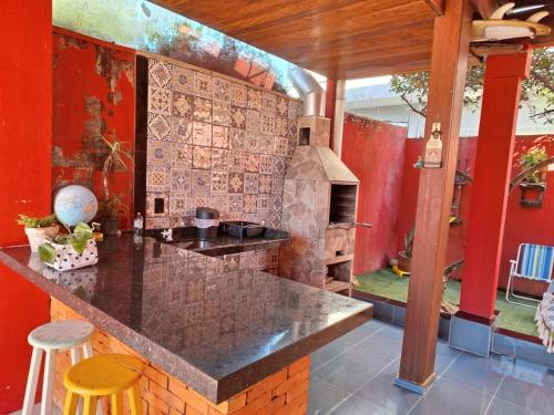 a kitchen with a counter and a brick wall at Casa chalé in Itajaí