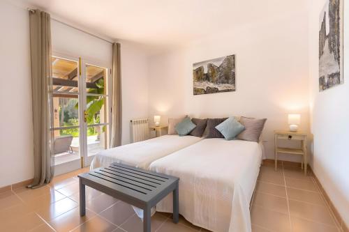 une chambre avec un lit blanc et une table dans l'établissement Pura Vida, à Son Servera