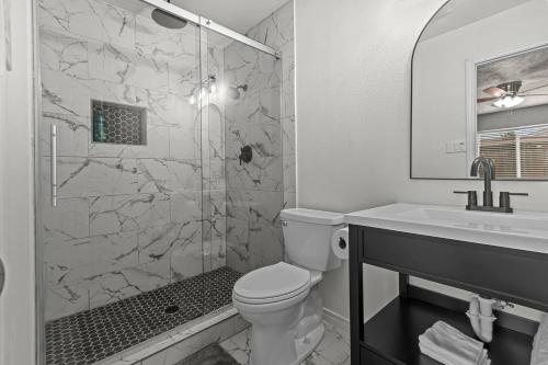 ein Badezimmer mit Dusche, Toilette und Waschbecken in der Unterkunft Private Hot Tub Near Dfw, Relaxing Texas Retreat in The Colony