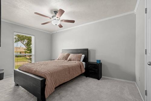ein Schlafzimmer mit einem Bett mit Deckenventilator in der Unterkunft Private Hot Tub Near Dfw, Relaxing Texas Retreat in The Colony