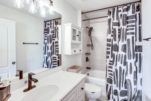 a bathroom with a sink and a shower curtain at Golf Getaway Cape Coral Condo 1 Mi to River! in Cape Coral Hospital Heliport