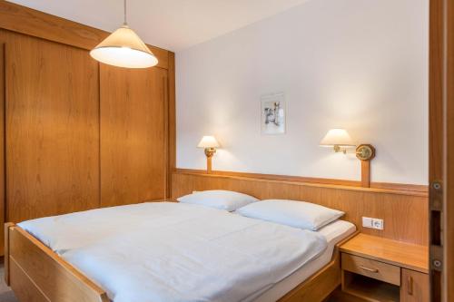 a bedroom with a large bed with a wooden headboard at Taufner Apartement C 106 in Parcines