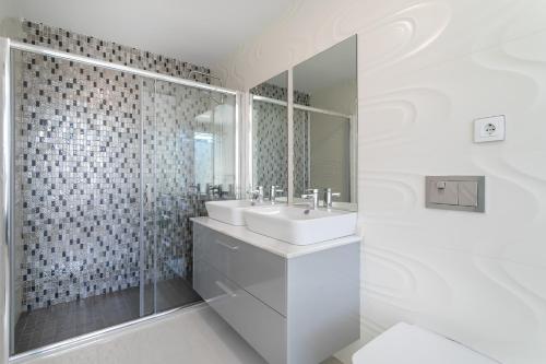 a white bathroom with a sink and a shower at Classy Holiday Home in Guardamar del Segura