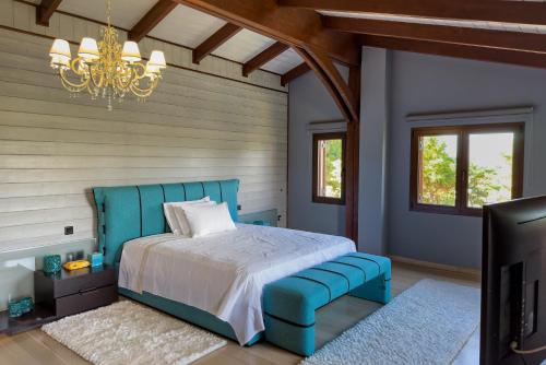 Néa PalátiaにあるPool Villa Desmiraのベッドルーム(青いベッド1台、シャンデリア付)