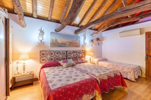 a bedroom with two beds in a room with wooden ceilings at El Sueño De Lucrecia in Villarrubia de Santiago