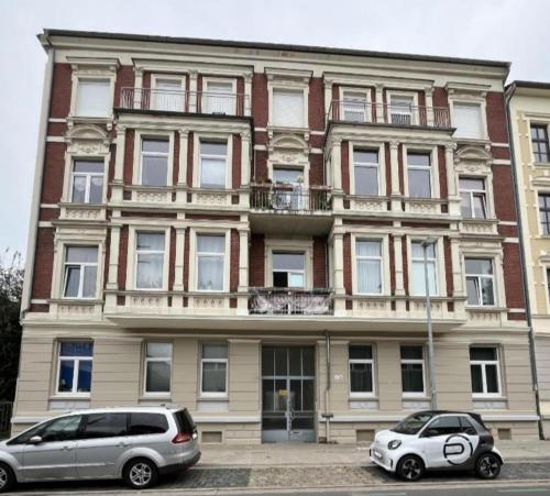 zwei Autos parkten vor einem großen Gebäude in der Unterkunft CityNest hannover S4 in Hannover