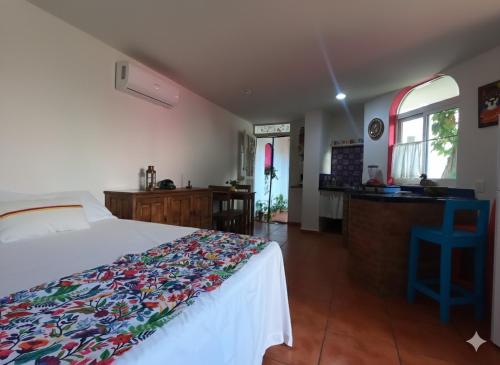 a bedroom with a bed with a colorful blanket on it at Casa Arbol de Paz Hab Sencilla in Chacala
