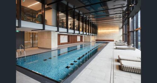 a large swimming pool in a building at Flinders St Central - Parking, Gym, Pool & Sauna in Melbourne
