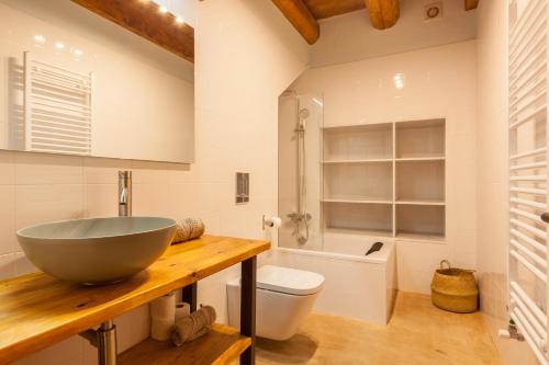 a bathroom with a bowl sink and a toilet at Masia Can Pla in San Mateo de Bages