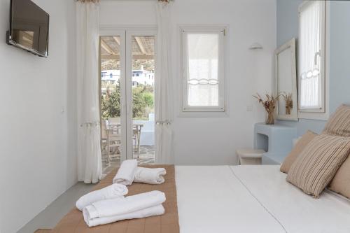 a white bedroom with two towels on the floor at Ninemia Suites Tinos Superior 202 in Kionia