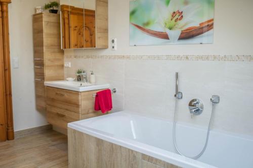 a bathroom with a tub and a sink at Ferienwohnung Bergpanorama in Garmisch-Partenkirchen