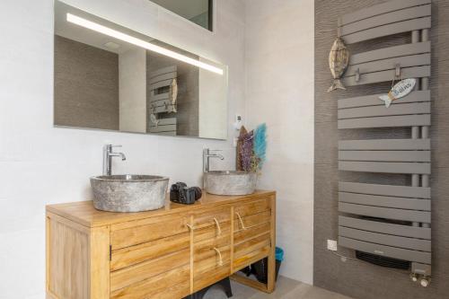 two sinks on top of a wooden dresser in a bathroom at Villa les Bleuets - proche Océan in Clohars-Carnoët