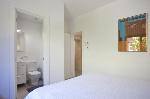 - une chambre blanche avec un lit et des toilettes dans l'établissement Villa Marimuntana, à Banyalbufar