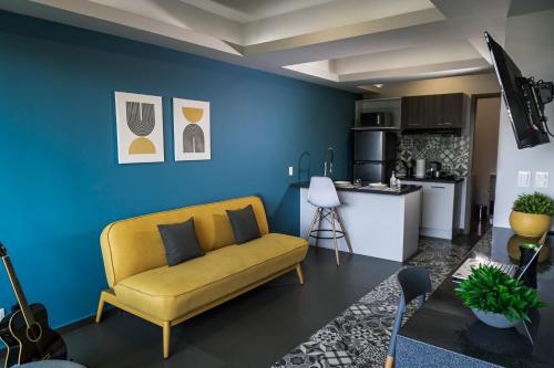 a living room with a yellow couch and a kitchen at NIU Modern Apartments near WTC & Condesa - Roma Sur in Mexico City