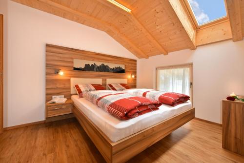 sypialnia z dużym łóżkiem z czerwonymi poduszkami w obiekcie Moarhof w mieście Rosa