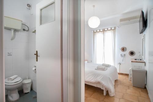 a white bathroom with a bed and a toilet at Livadia Seaside Studios 13 in Parikia