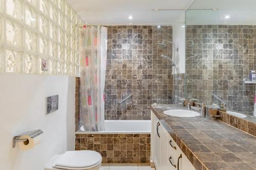 Un baño con inodoro, bañera y lavabo. en Lovely Villa Las Palmeras, en Marbella