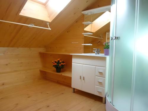 cocina con paredes de madera y techo con tragaluz. en Deux grands chalets communicants, en Les Orres