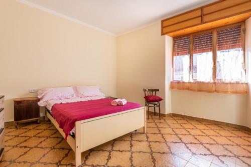 a bedroom with a bed with a red blanket at Casa di Stefania in Fluminimaggiore