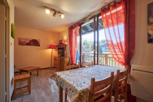 a room with a table and a window with a view at 2 Alpes - appartement 2-4 pers in Les Deux Alpes