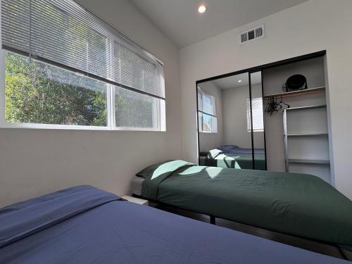 a bedroom with two beds and a window at Blue Central Stay Near USC, BMO Stadium & Downtown LA in Los Angeles