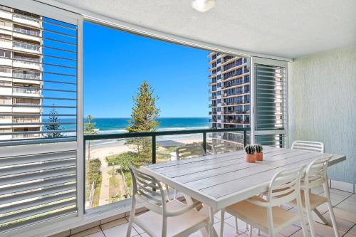 a dining room with a table and views of the beach at Emerald Sands Holiday Apartments in Gold Coast