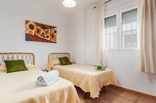 ein Zimmer mit zwei Betten und einem Fenster in der Unterkunft Apartamento de alquiler en Barbate in Barbate