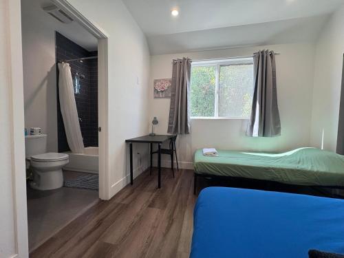 a small room with a bed and a toilet and a window at Blue Central Stay Near USC, BMO Stadium & Downtown LA in Los Angeles