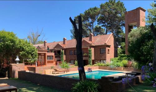una casa con piscina en el patio en Tiempo Compartido Clermont Pinamar, en Pinamar
