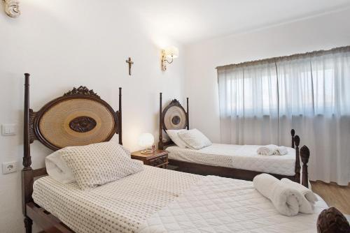 a bedroom with two beds and a cross on the wall at Refúgio de Fátima in Fátima