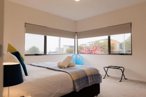 a bedroom with a large bed with two windows at Bicheno Sands-space and the sea in Bicheno