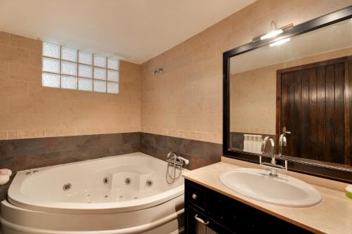 a large bathroom with a tub and a sink at Atalaya in Santa Eulalia la Mayor