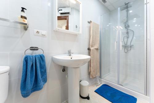 a white bathroom with a sink and a shower at 234 Parque playa La cala in La Cala de Mijas