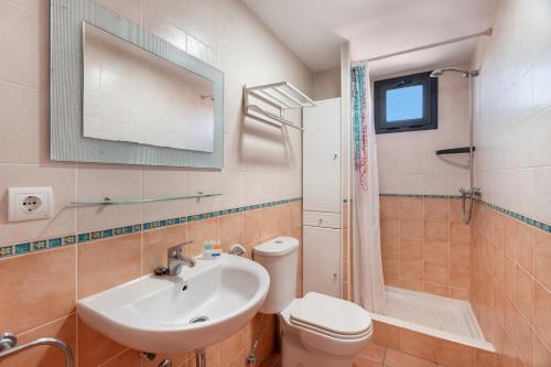 a bathroom with a sink and a toilet and a mirror at La Mathilda Playa Paraiso in Adeje