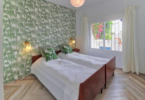 two beds in a bedroom with green wallpaper at Villa, Private pool and great views in Mijas Costa