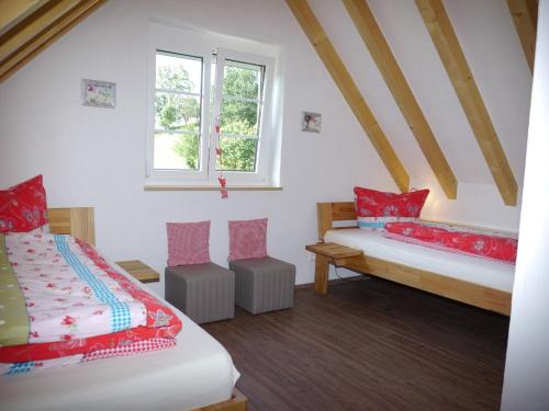 a bedroom with two beds and a window at Kapellenhof in Glottertal