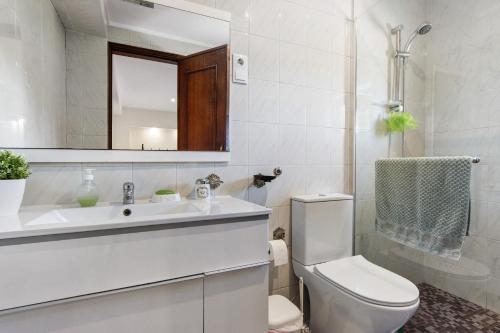 a bathroom with a toilet and a sink and a mirror at Estúdio entre Porto e Aveiro in Carregosa