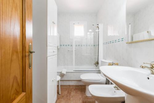 ein Badezimmer mit Waschbecken, Toilette und Dusche in der Unterkunft Jardin del Golf in Chiclana de la Frontera