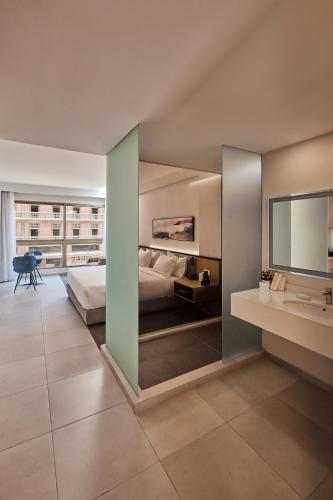 a large bedroom with a bed and a sink at The View - Saint George Hotel in Beirut