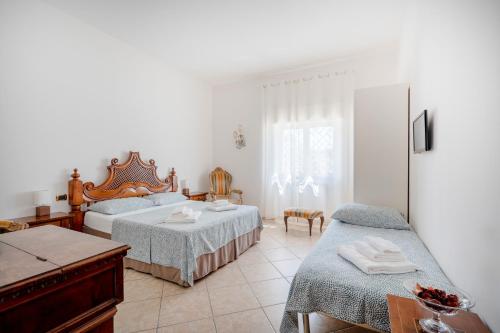 バーリにあるBnb Villa Luciaのベッド2台とテーブルと椅子のある寝室