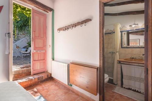 a bathroom with a red door and a sink at Casa Rural La Rana Verde in Los Romeros